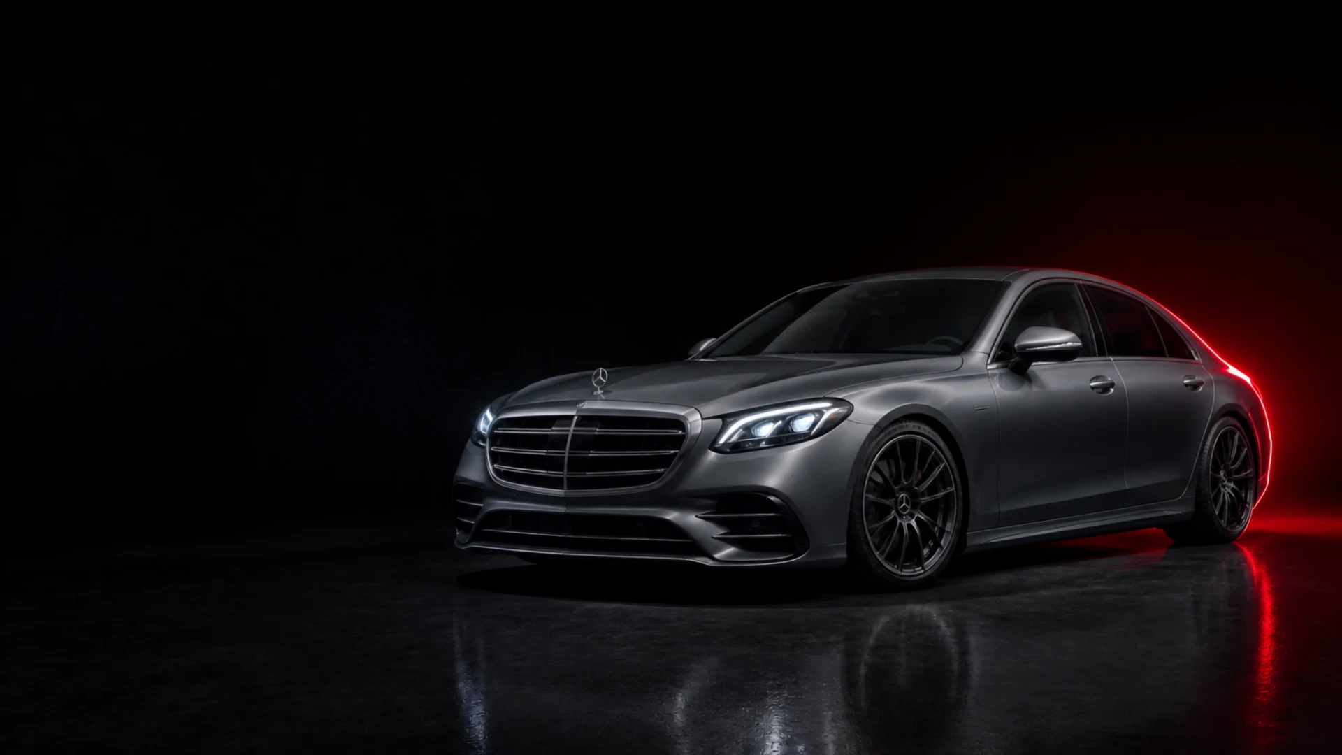 Graue Mercedes-Benz S-Klasse im dunklen Studio mit rotem Licht, Symbolbild KI-generiert