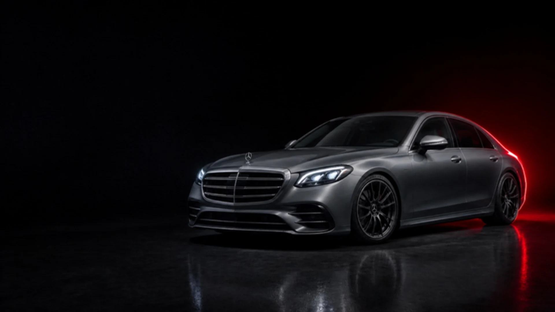 Graue Mercedes-Benz S-Klasse im dunklen Studio mit rotem Licht, Symbolbild KI-generiert
