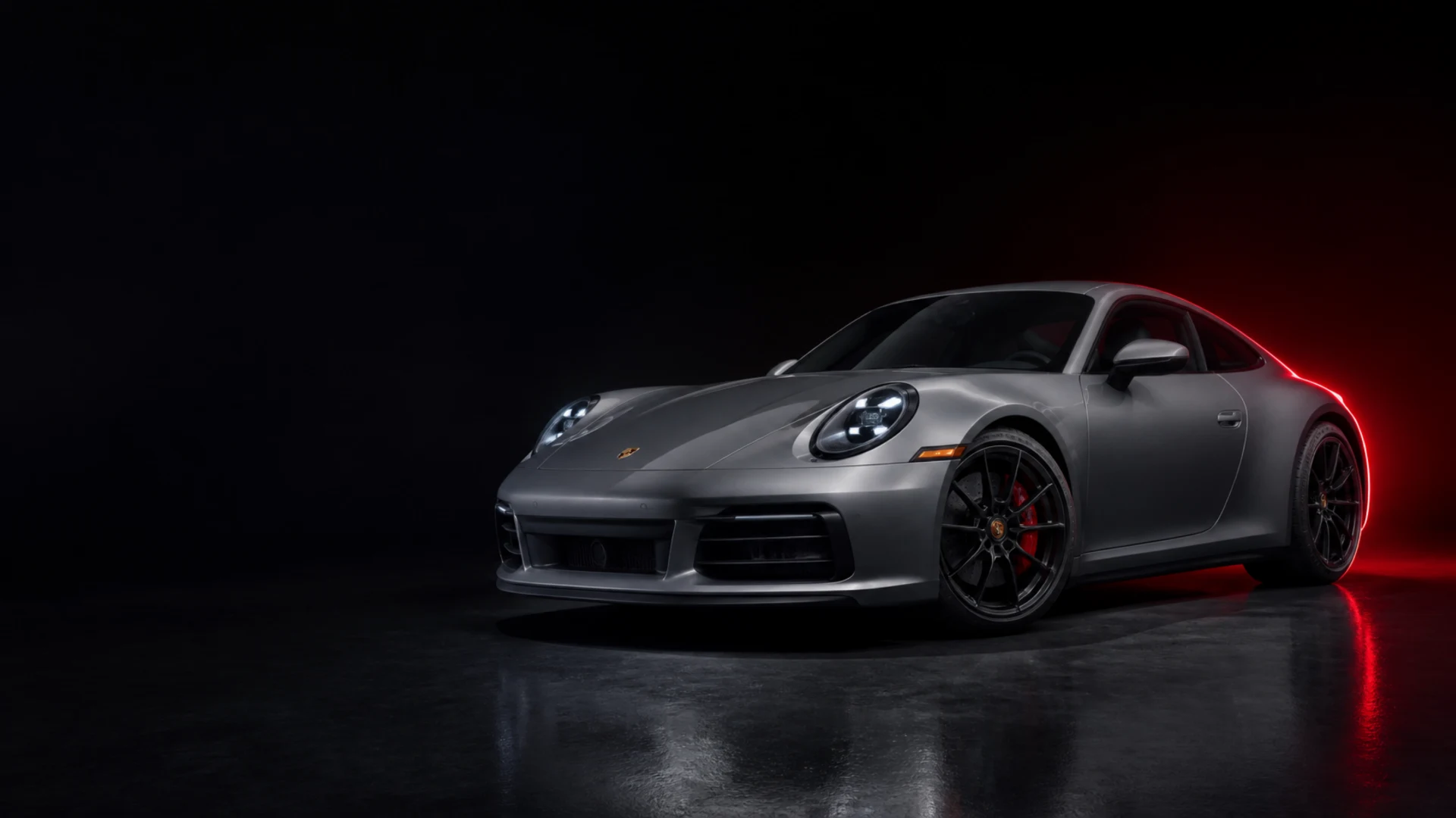 Grauer Porsche 911 im dunklen Studio mit rotem Licht, Symbolbild KI-generiert