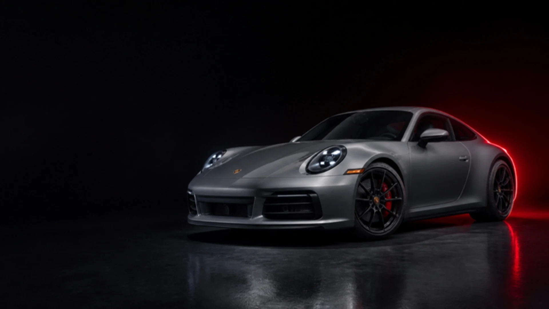 Grauer Porsche 911 im dunklen Studio mit rotem Licht, Symbolbild KI-generiert