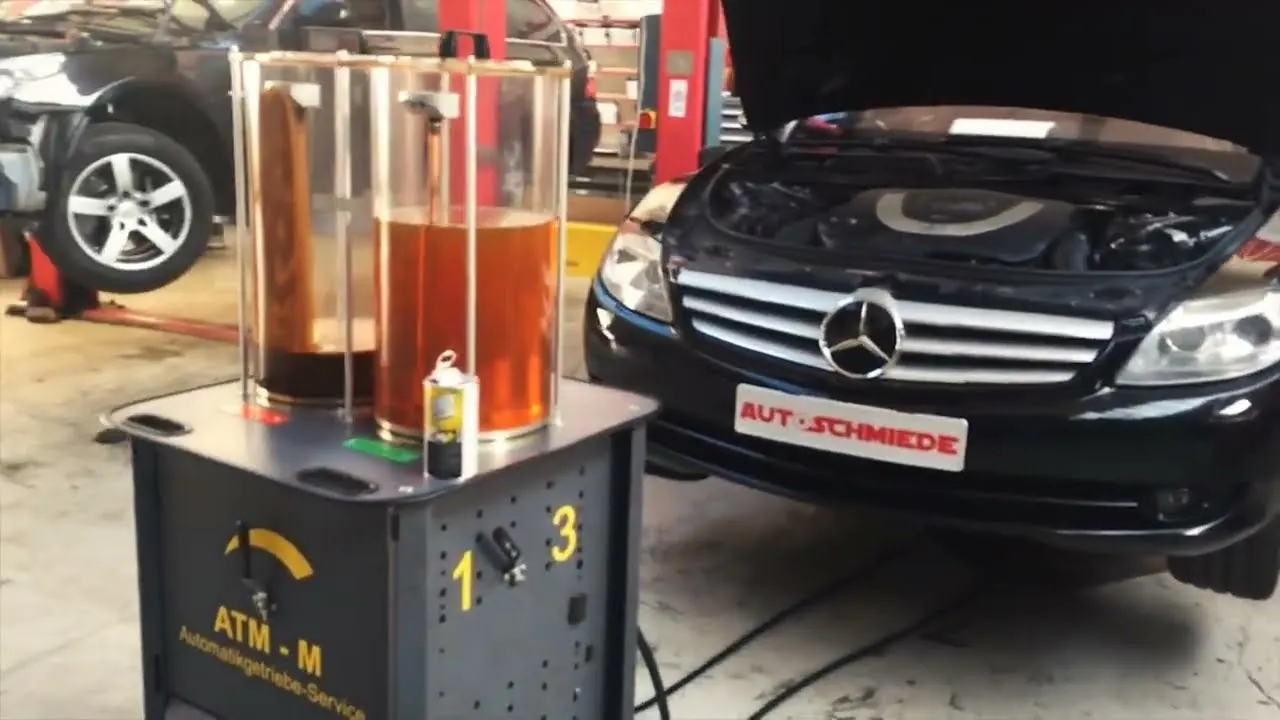 Getriebespülgerät mit Alt- und Frischöl vor einem Mercedes-Benz in der AUTOSCHMIEDE